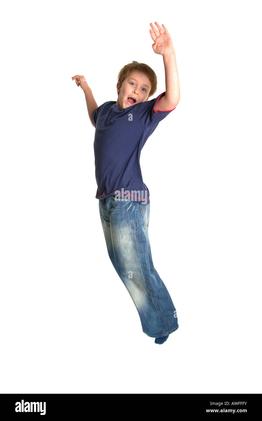 A young boy jumping in the air against a white background slight motion blur Stock Photo