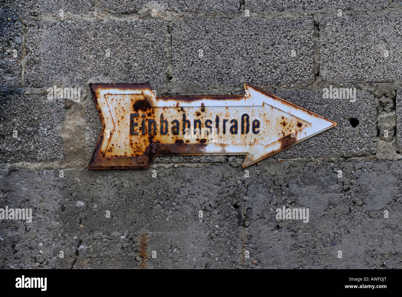 Rusted old traffic sign on a concrete wall, 'Einbahnstrasse' (one-way street) Stock Photo