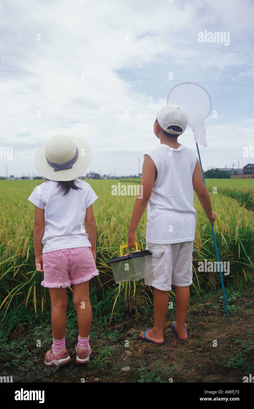 Boy and girl standing in rice paddy Stock Photo - Alamy