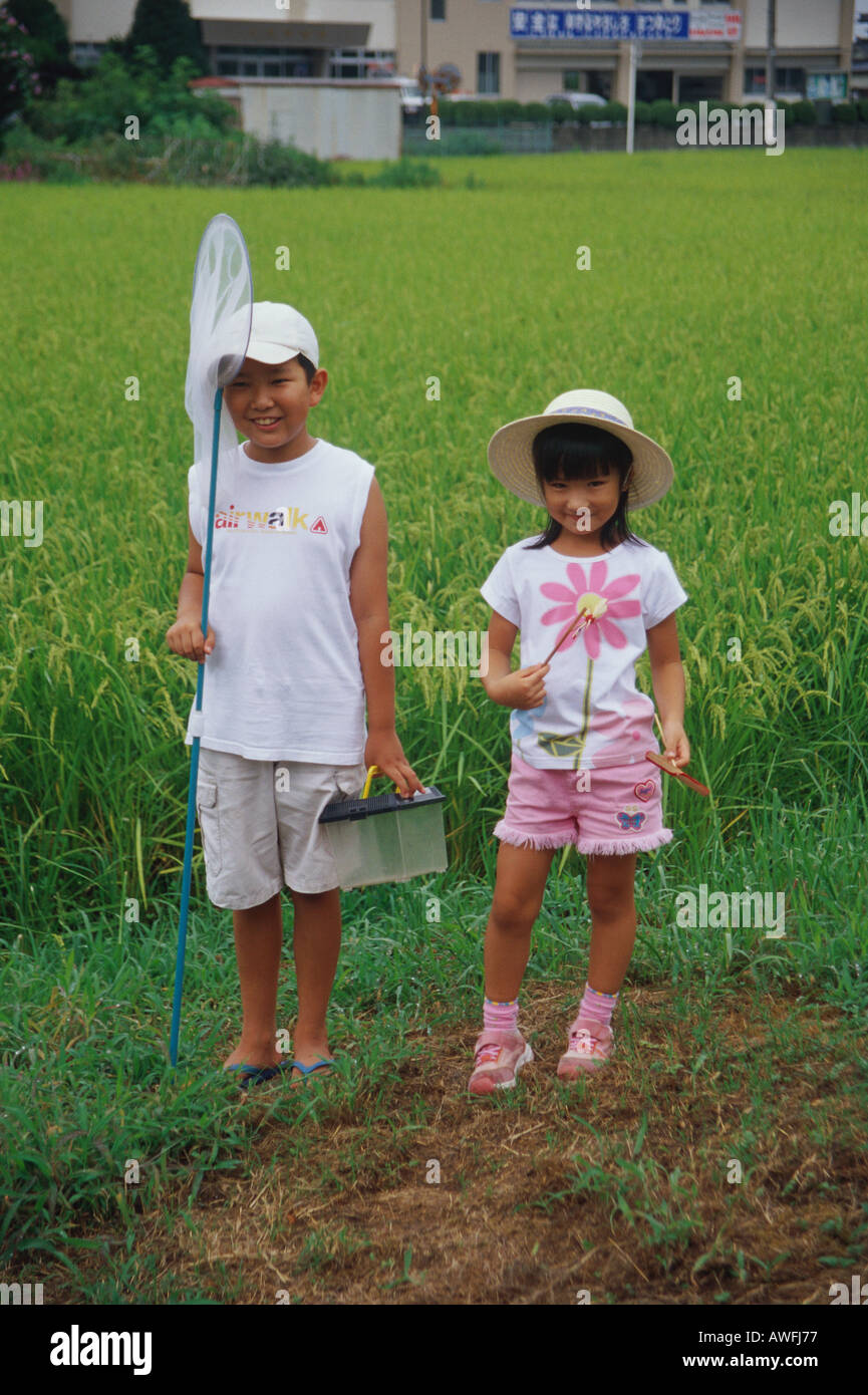 Boy and girl standing in rice paddy Stock Photo - Alamy
