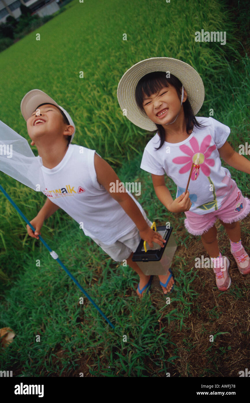 Boy and girl standing in rice paddy Stock Photo - Alamy
