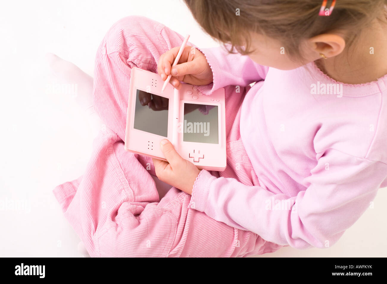 pink dressed girl with pink gameboy Stock Photo