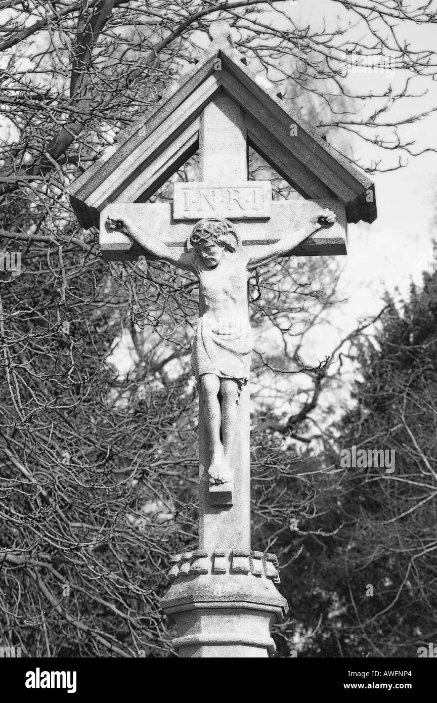 Memorial cross showing the crucifixion in black and white with a diffuse glow effect added Stock Photo