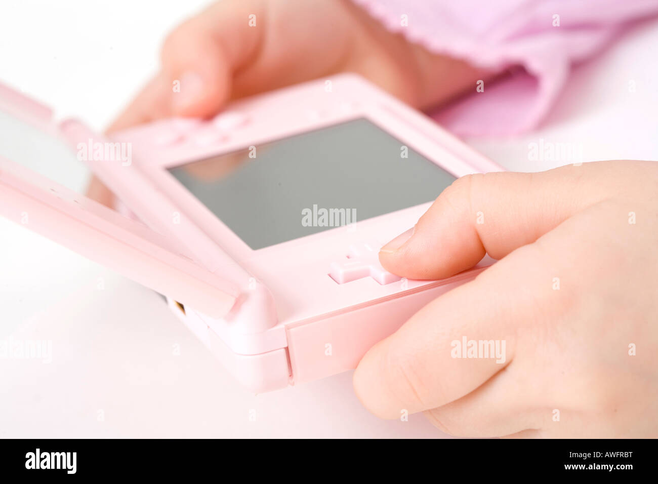 pink dressed girl with pink gameboy Stock Photo