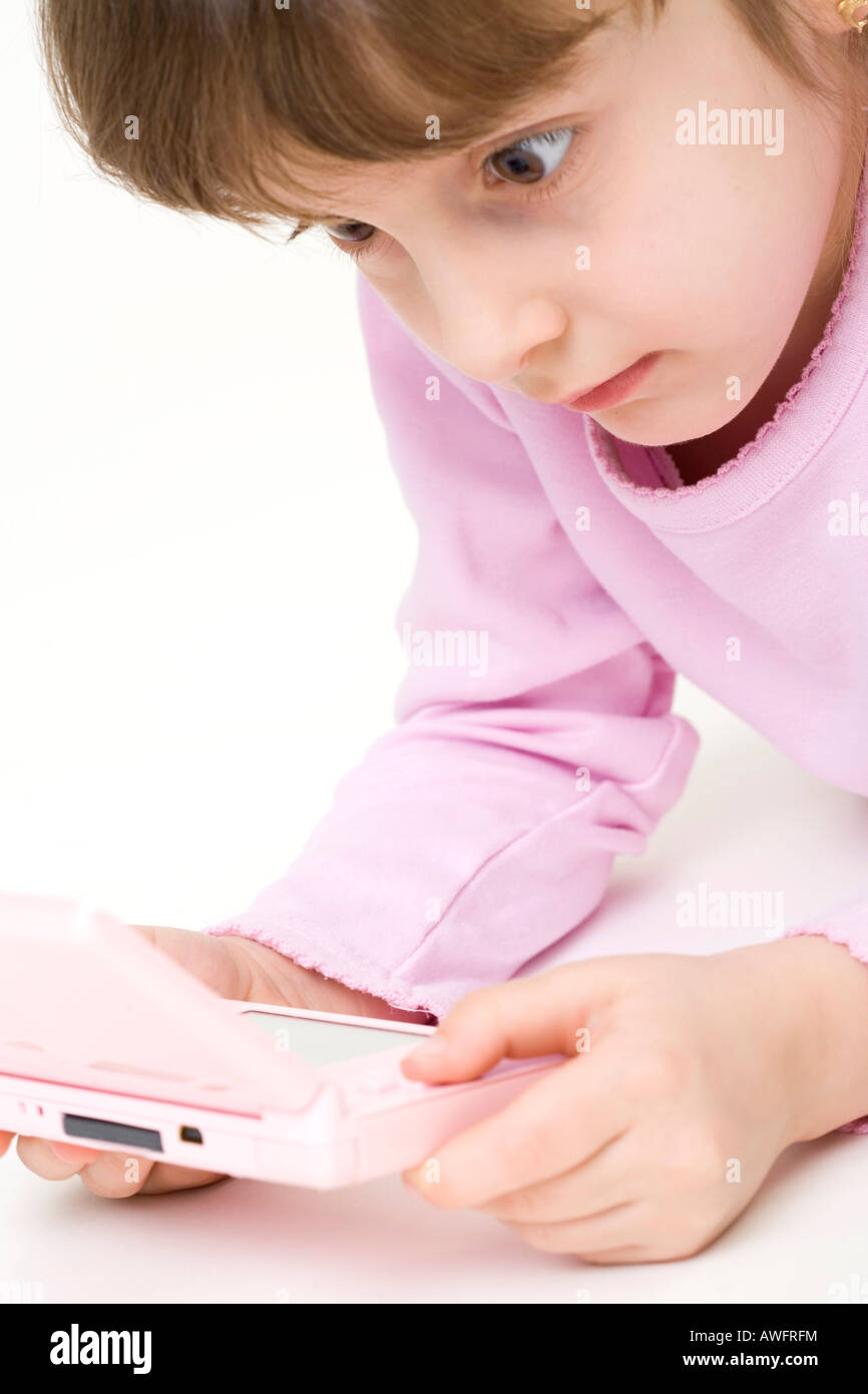 pink dressed girl with pink gameboy Stock Photo