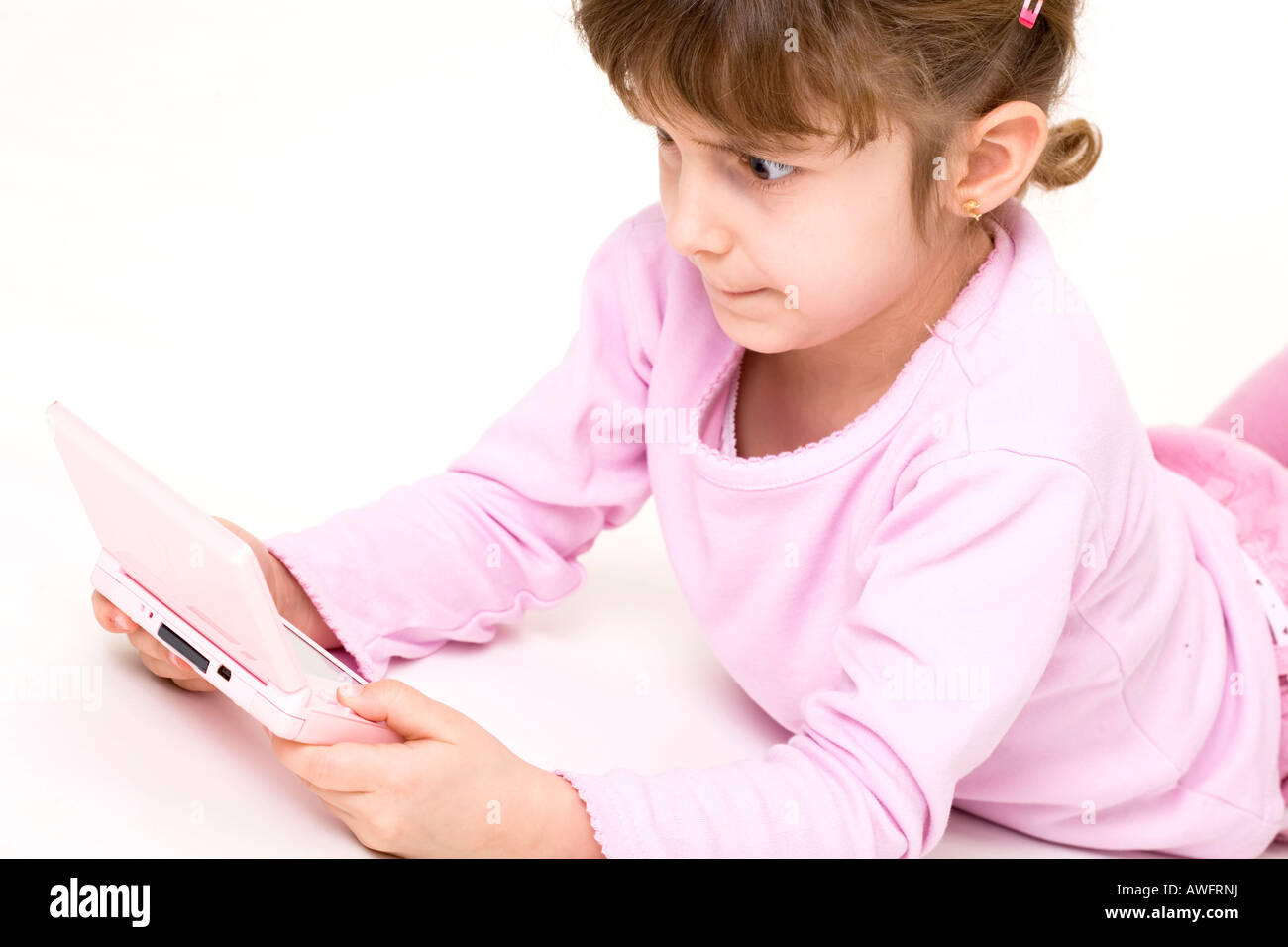 pink dressed girl with pink gameboy Stock Photo