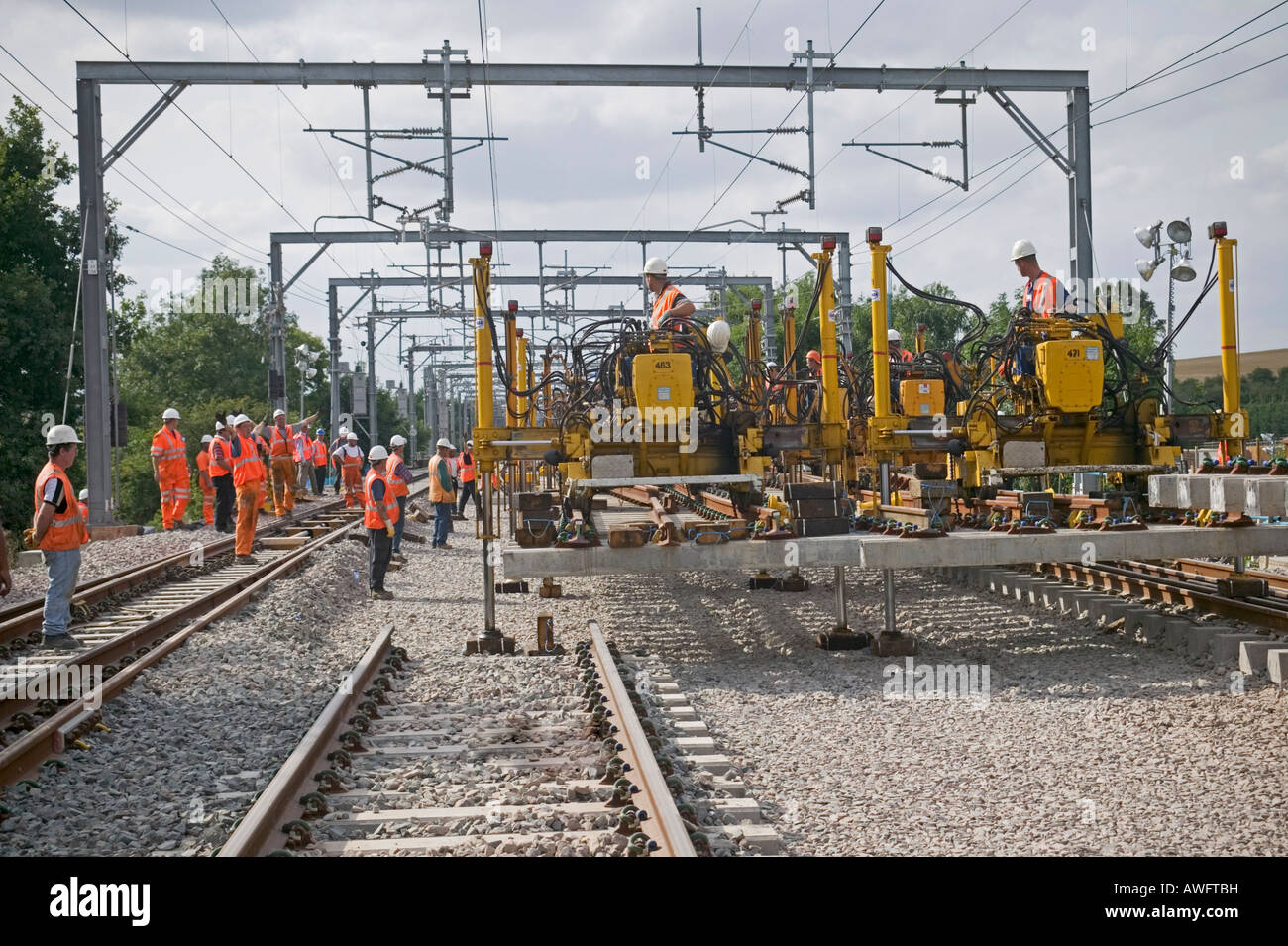 Rail contractors using modular replacement system to replace worn-out track by installing prefabricated panels on a busy railway Stock Photo