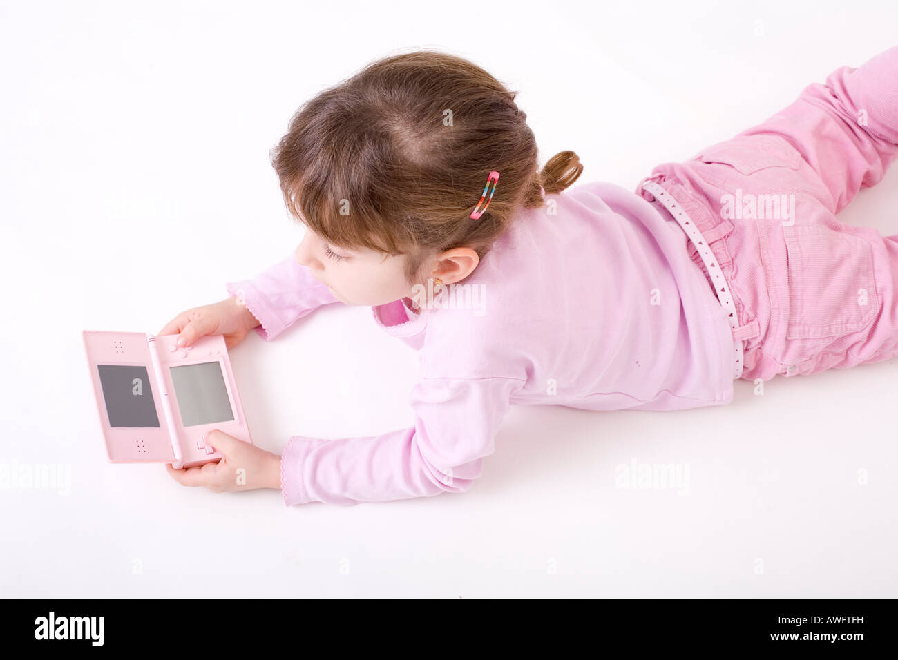 pink dressed girl with pink gameboy Stock Photo