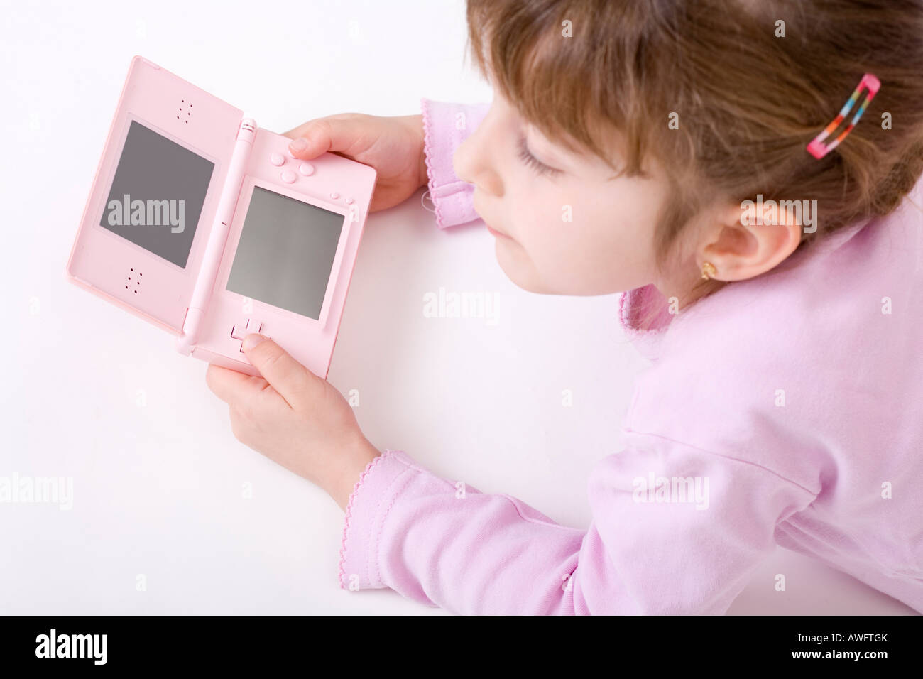 pink dressed girl with pink gameboy Stock Photo