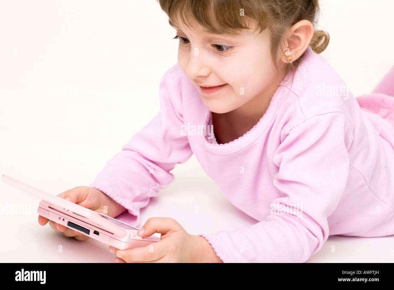 pink dressed girl with pink gameboy Stock Photo