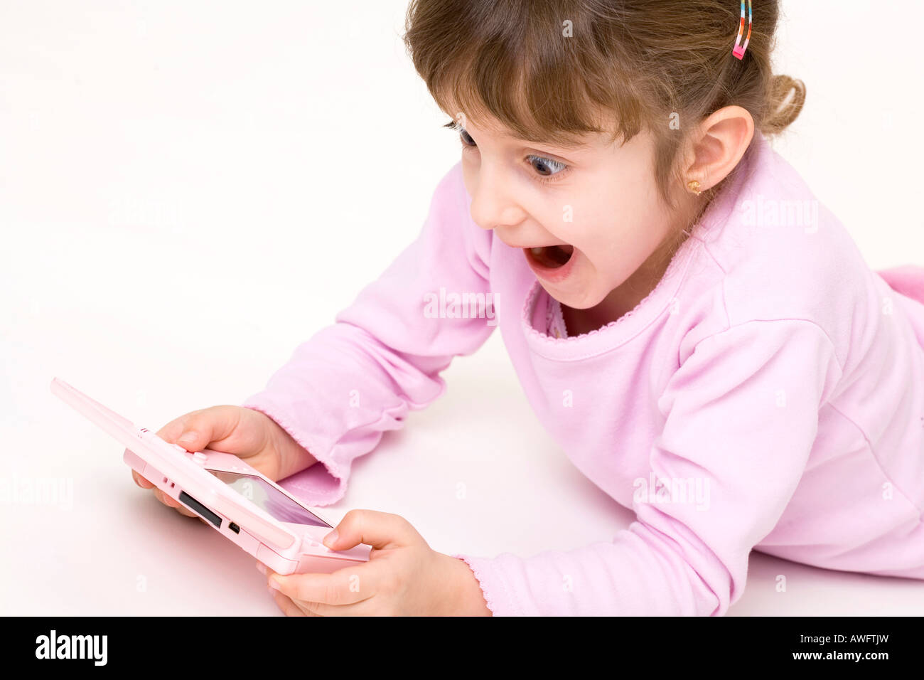 pink dressed girl with pink gameboy Stock Photo
