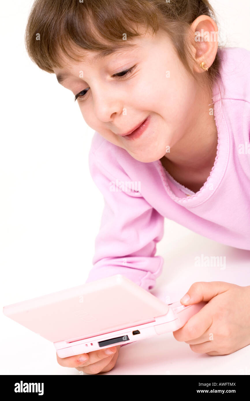 pink dressed girl with pink gameboy Stock Photo
