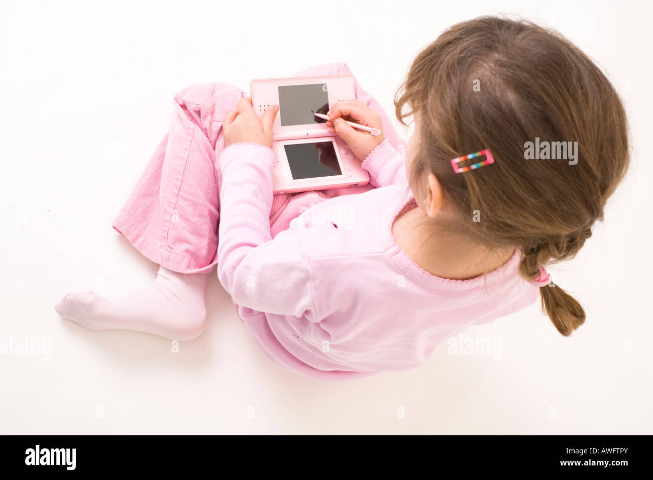pink dressed girl with pink gameboy Stock Photo