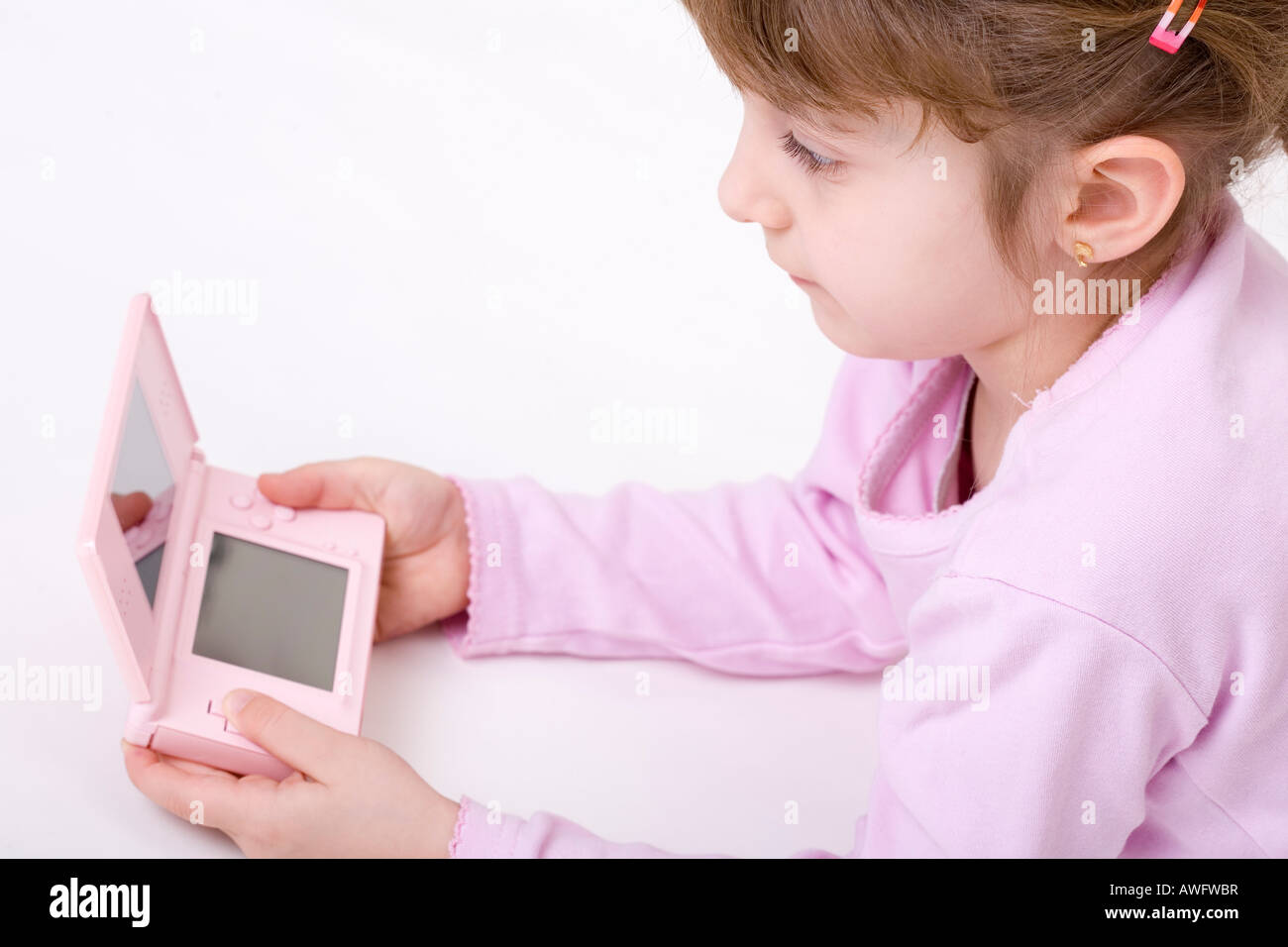 pink dressed girl with pink gameboy Stock Photo