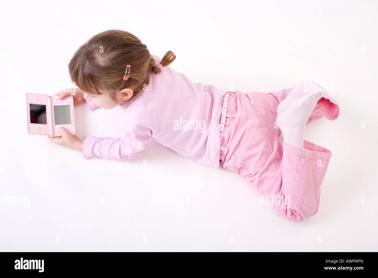 pink dressed girl with pink gameboy Stock Photo