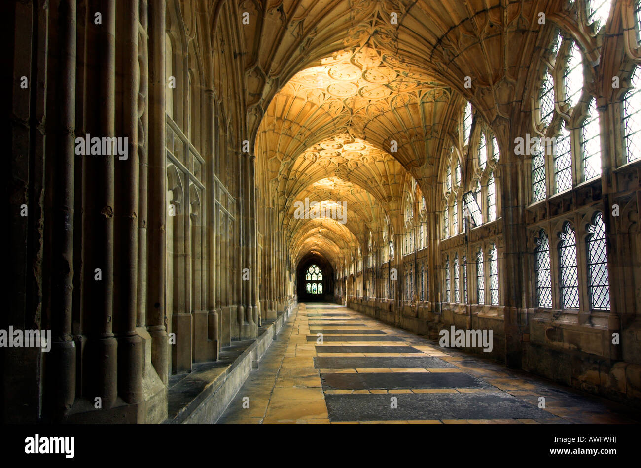 A view along the beautiful cloisters of Gloucester Cathedral with a tomb in the floor and the famous fan vaulted ceiling Stock Photo