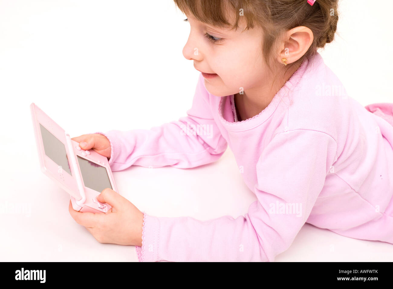 pink dressed girl with pink gameboy Stock Photo