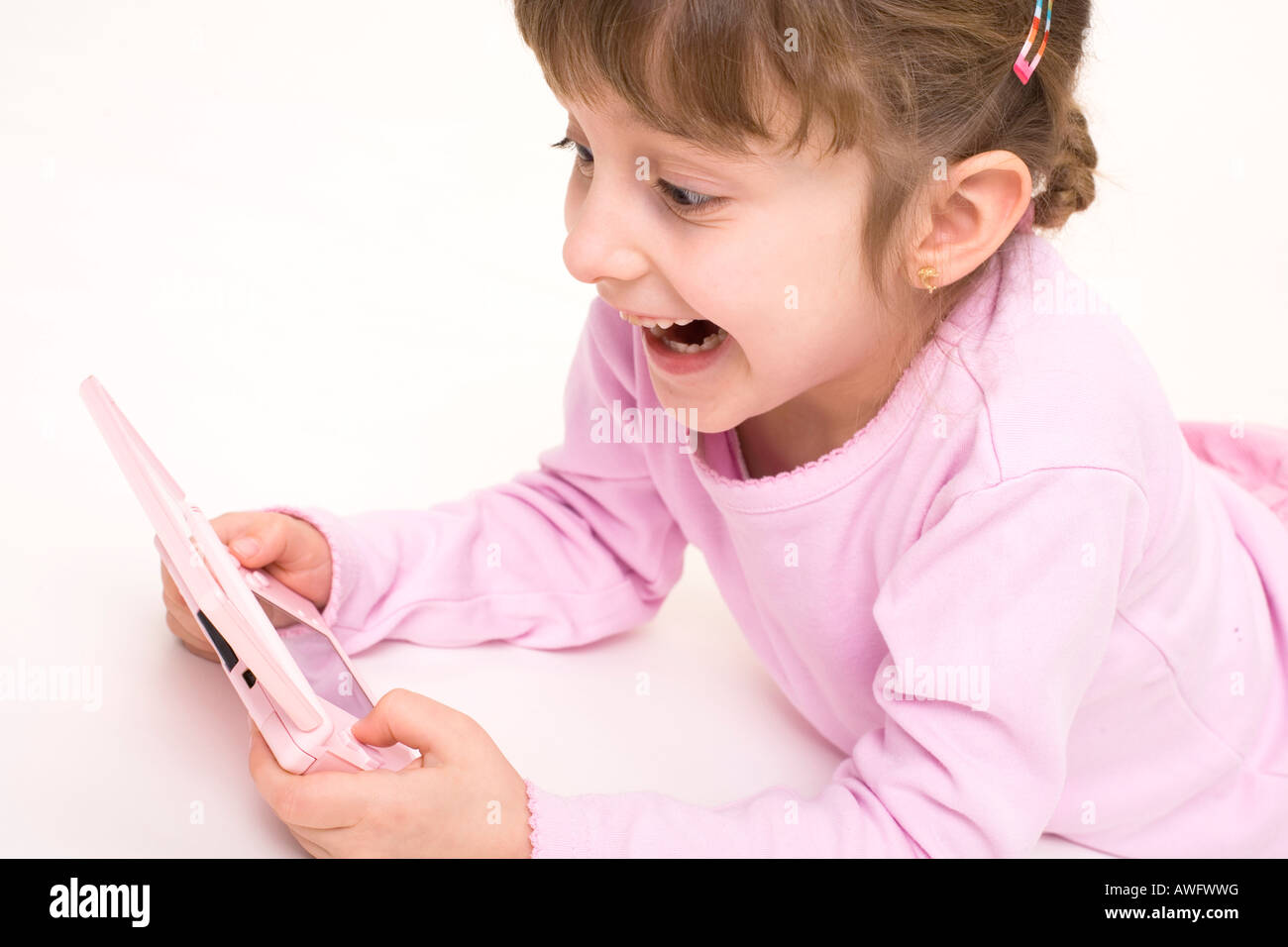 pink dressed girl with pink gameboy Stock Photo