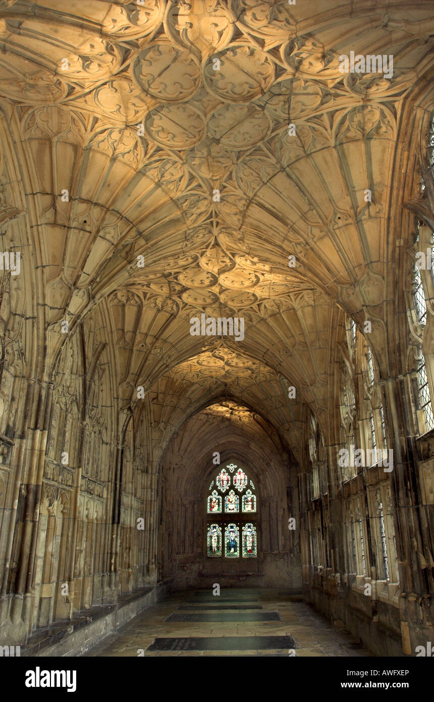 A view along the beautifil cloisters of Gloucester Cathedral with a tomb in the floor and the famous fan vaulted ceiling Stock Photo