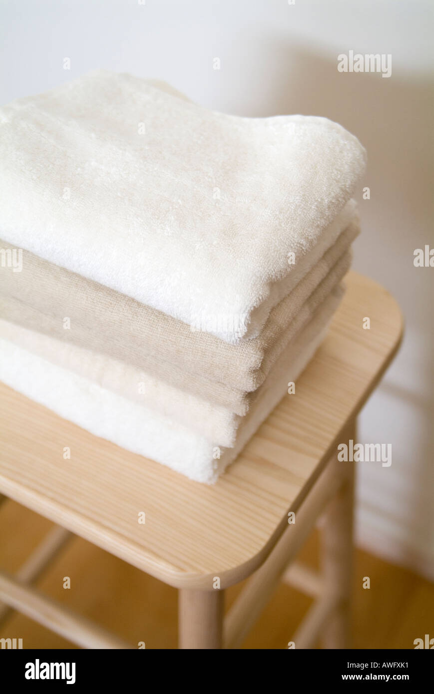 Folded towels on stool Stock Photo