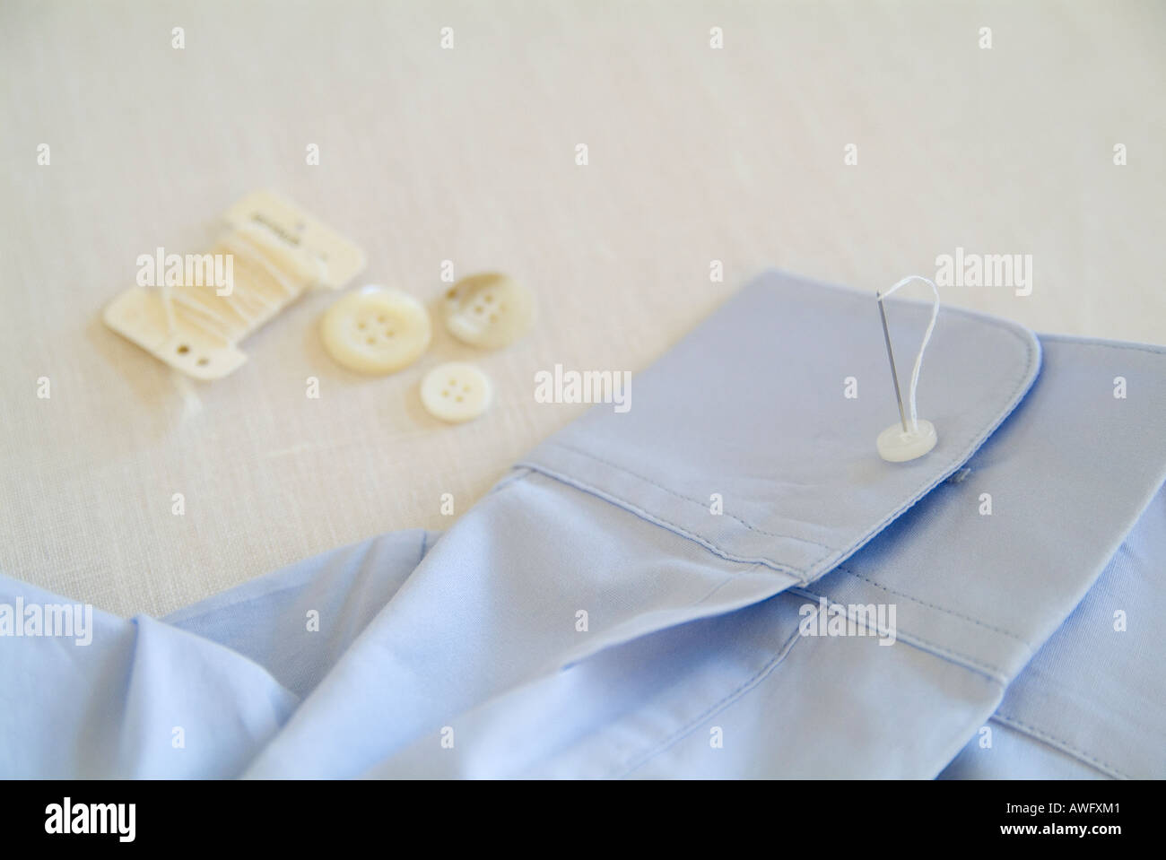 Sewing button on shirt Stock Photo Alamy