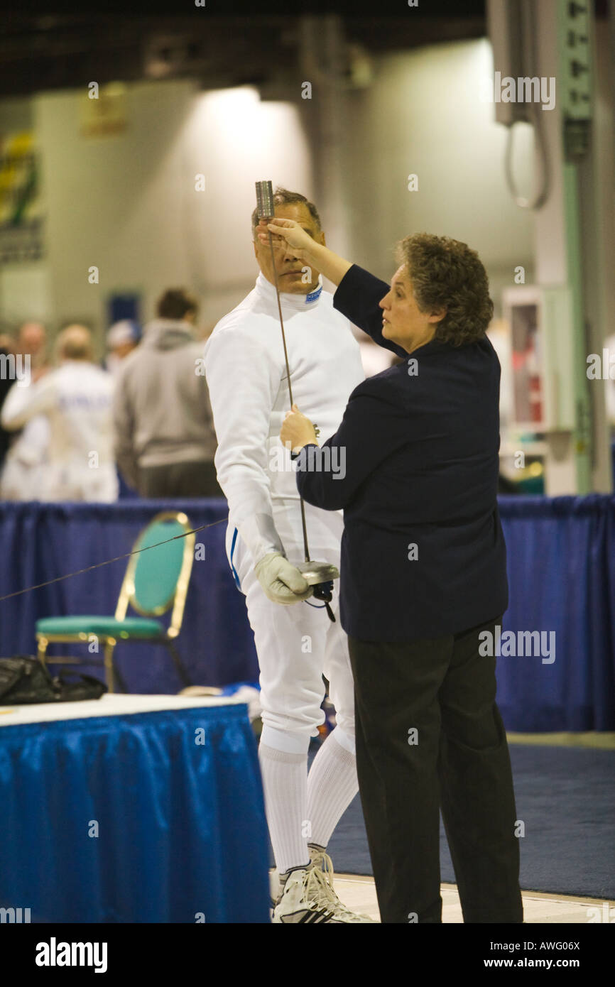 SPORTS Fencing competition bout female referee test weapon of male epee competitor on strip