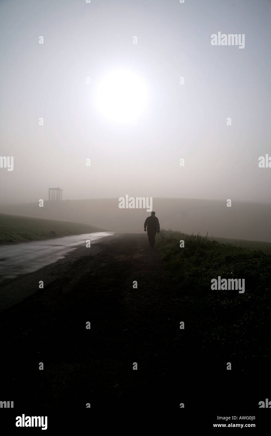 Man walking in early morning mist on Epsom Downs, Surrey Stock Photo