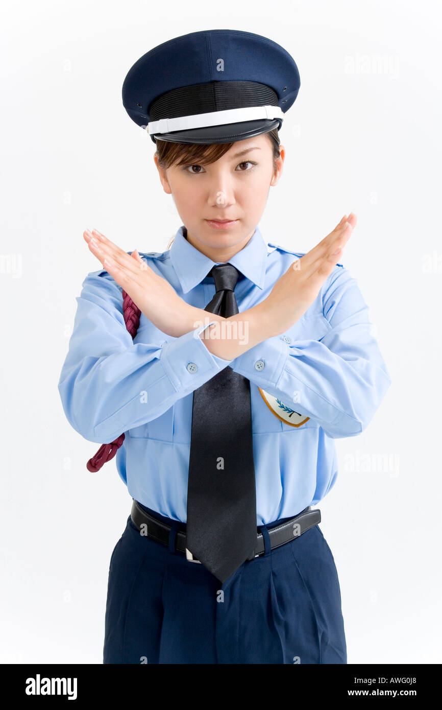 A female security guard standing with her arms crossed Stock Photo