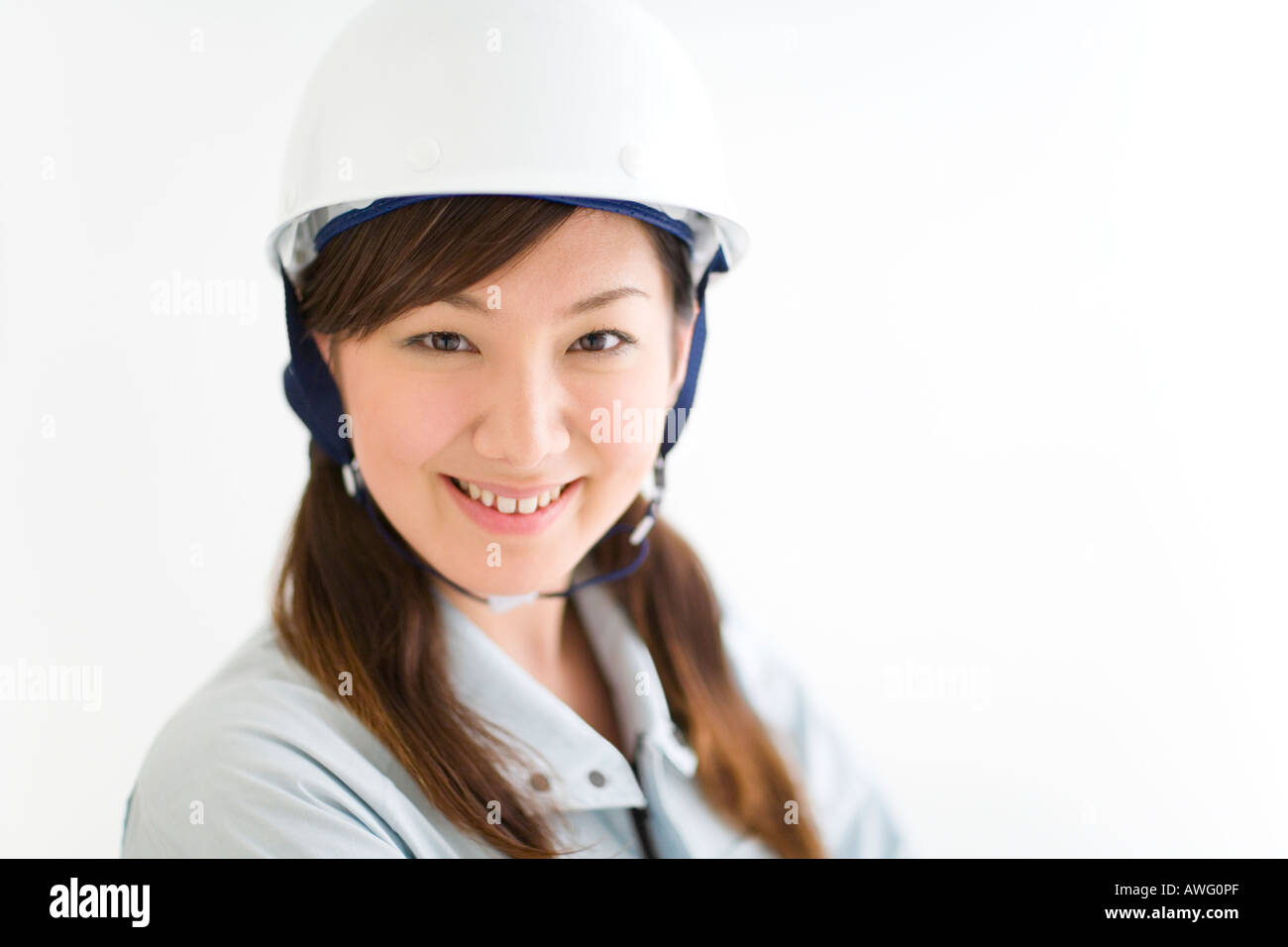 A female construction worker wearing a hardhat Stock Photo