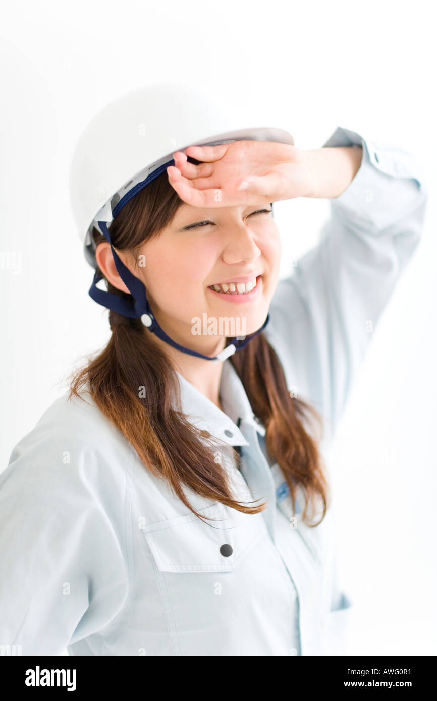 A female construction worker wiping sweat Stock Photo
