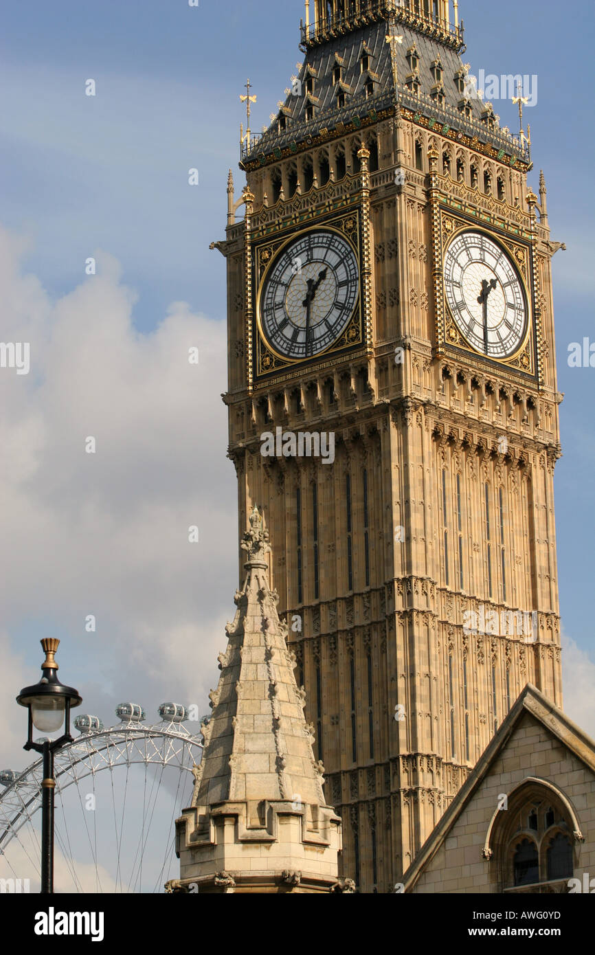Closeup of world famous clock tower Big Ben with London Eye wheel