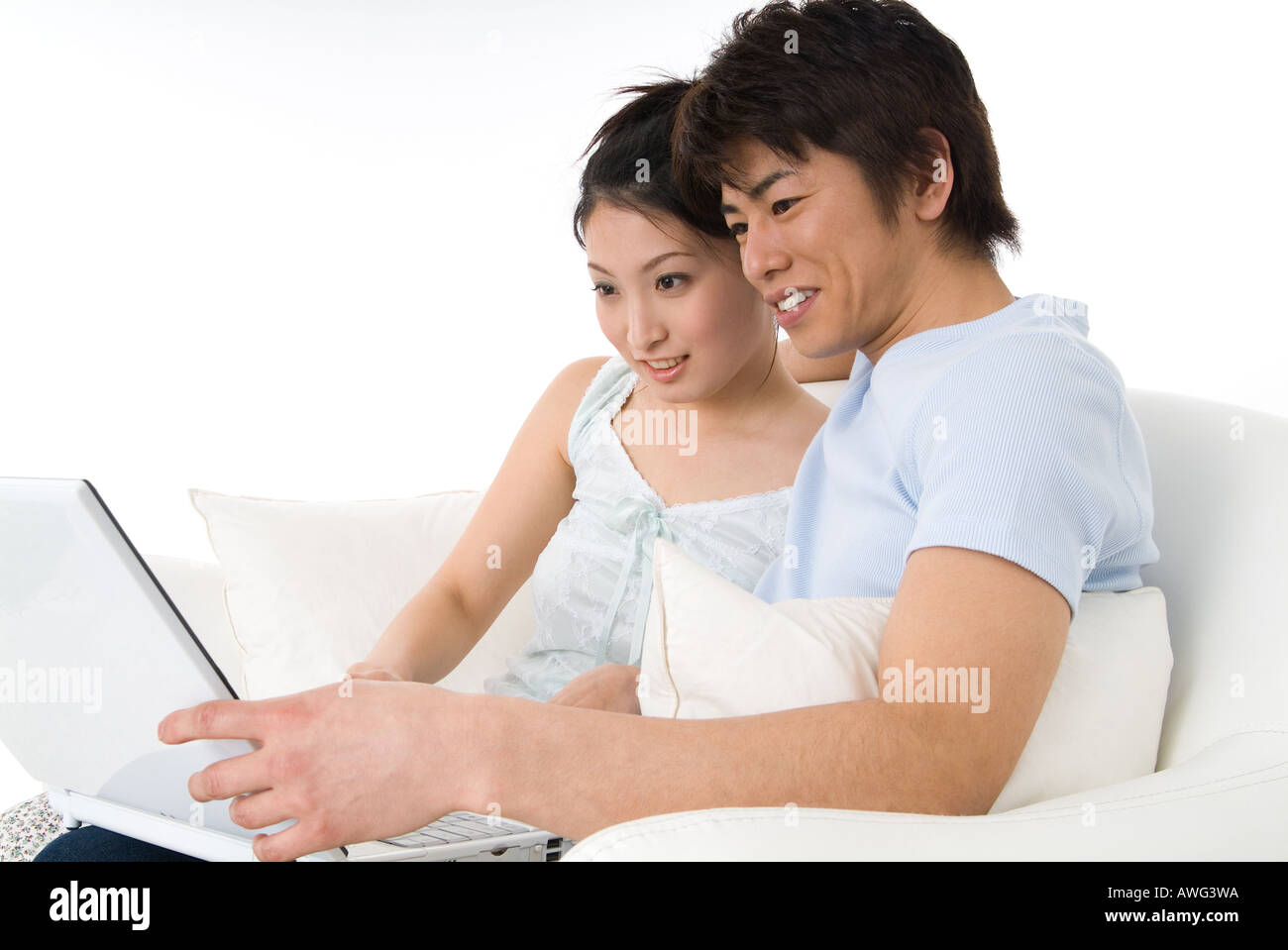 Young couple sitting and looking at laptop computer Stock Photo
