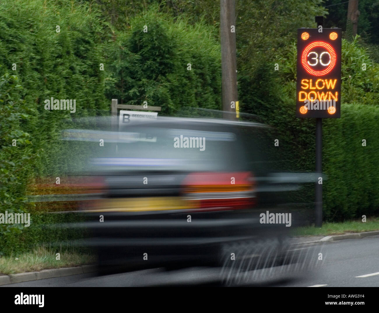 Car moving past 30 MPH illuminated speed limit reminder A2100 Battle East Sussex England Britain UK Stock Photo