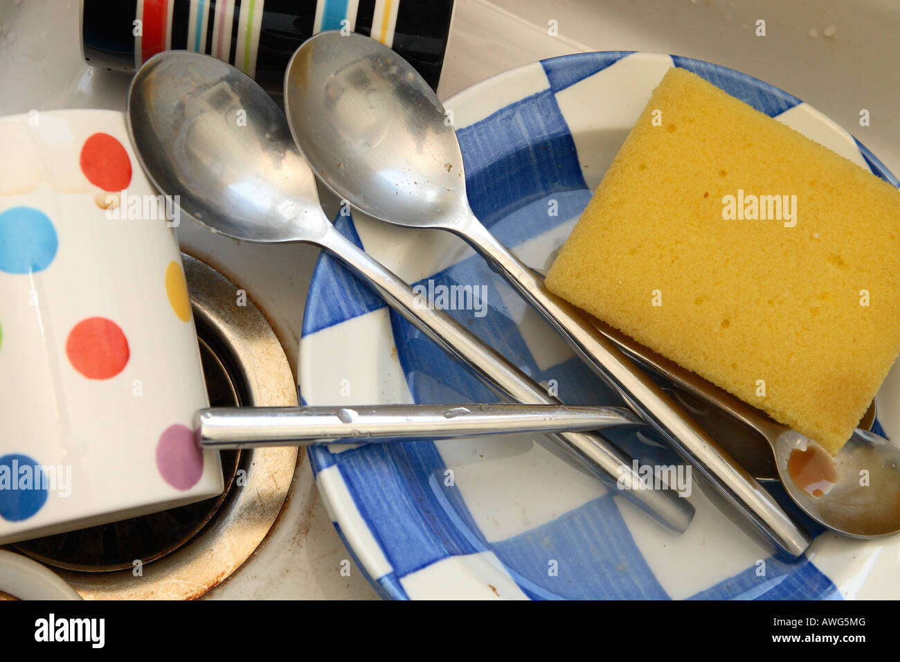 Washing up dirty dishes crockery cup mug bowl spoon cutlery in the