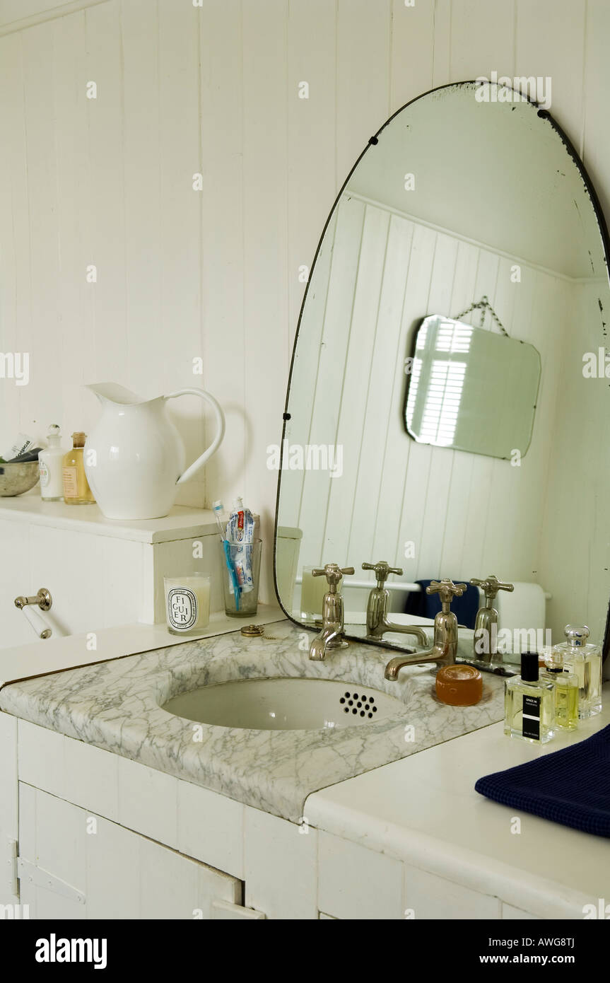 Mirror and marbled washbasin in bathroom of London townhouse Stock Photo