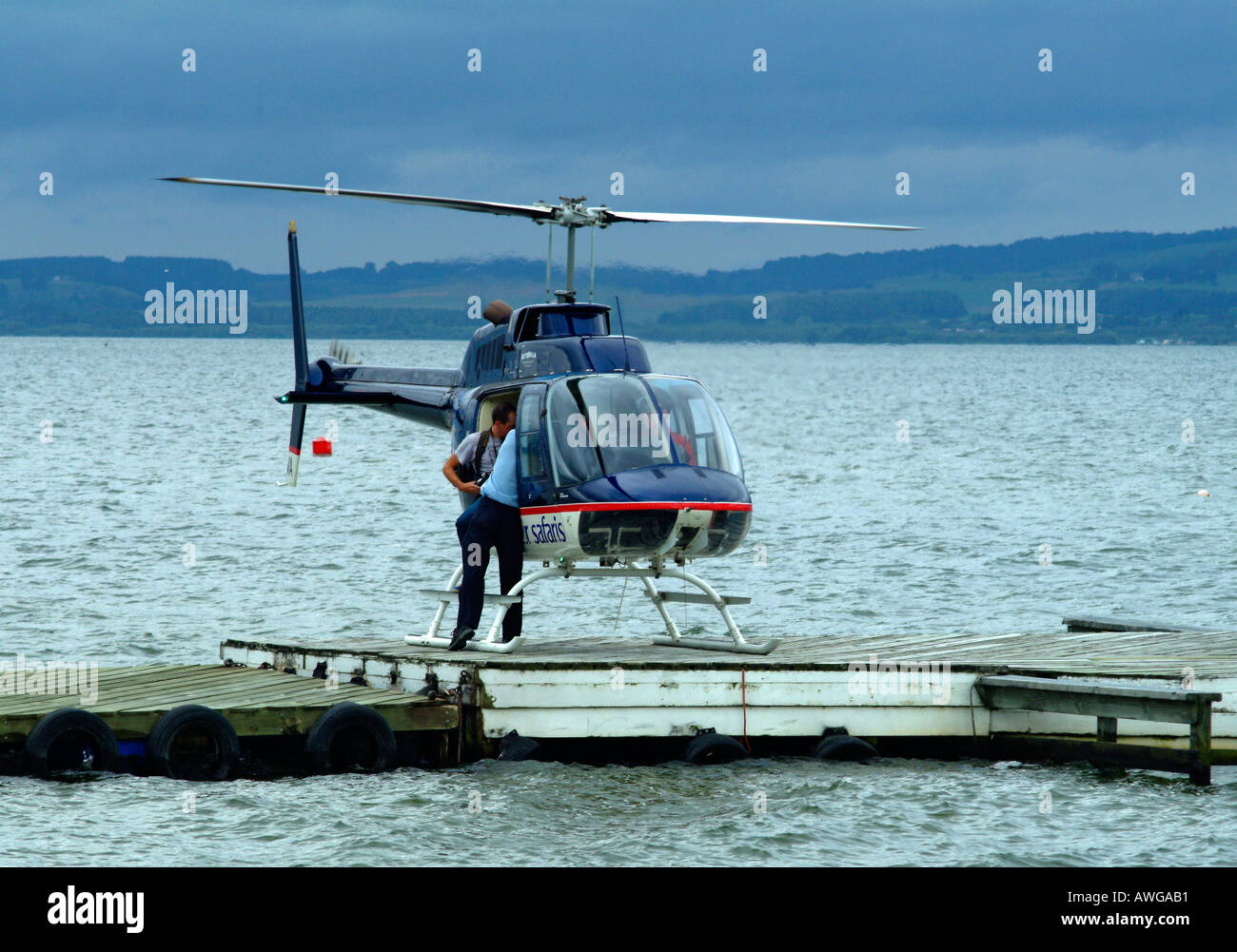 Helicopter and pilot on the ground Lake Taupo North Island New Zealand Stock Photo