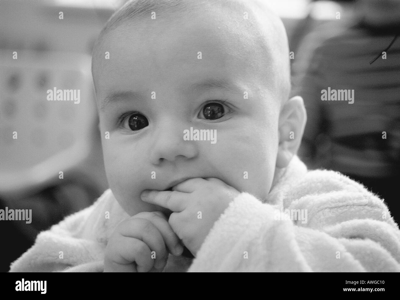 A baby with hand in mouth Stock Photo