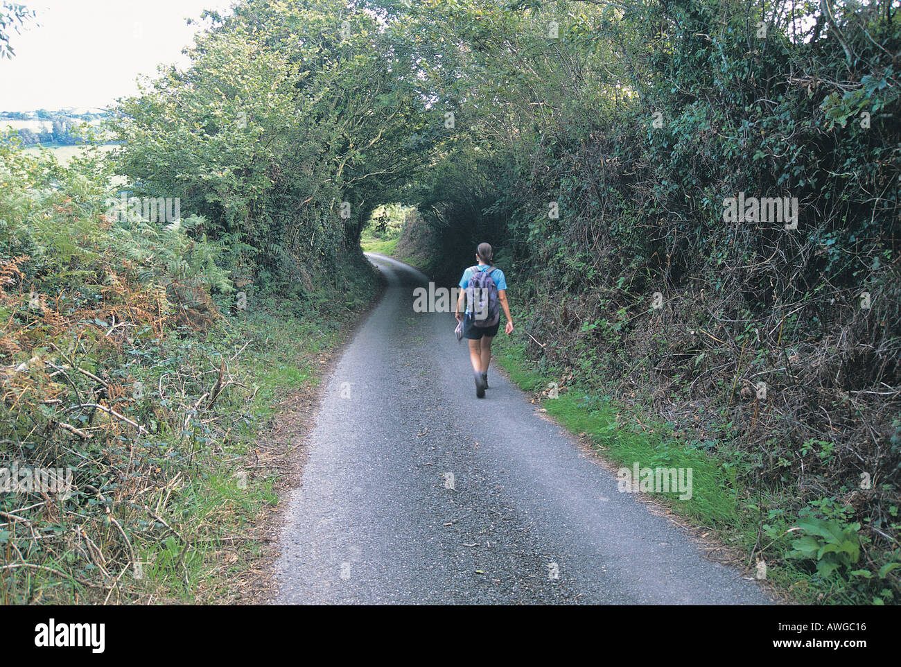 Woman walking on country lane hi-res stock photography and images - Alamy