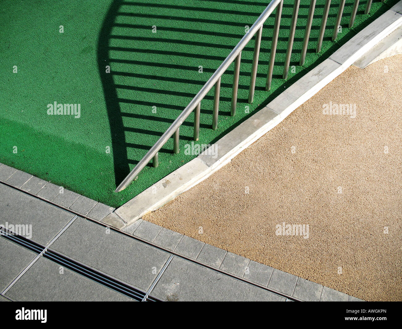 A part of floor pattern from public playground at vivo city, Singapore and juxtapose it with the shadow of metal hand railing Stock Photo