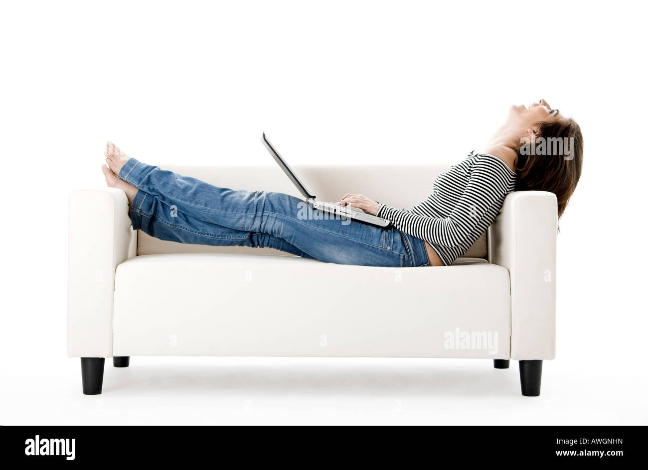 Beautiful woman on a white sofa with a laptop Stock Photo - Alamy