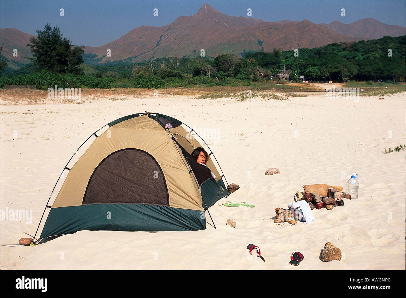 Hong Kong, Tai Long Wan Coastline, camper peering from tent on beach