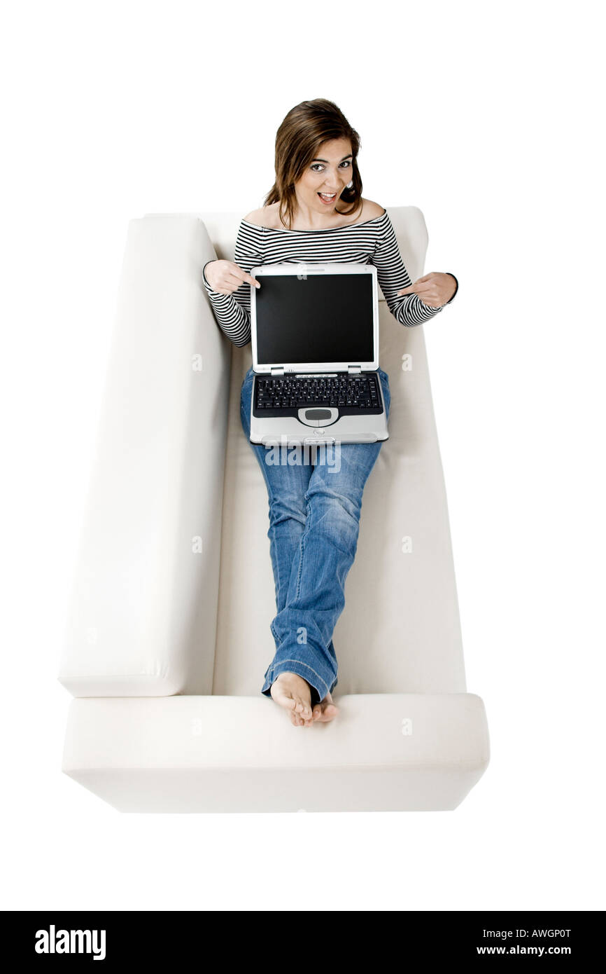 Beautiful woman on a white sofa with a laptop Stock Photo - Alamy