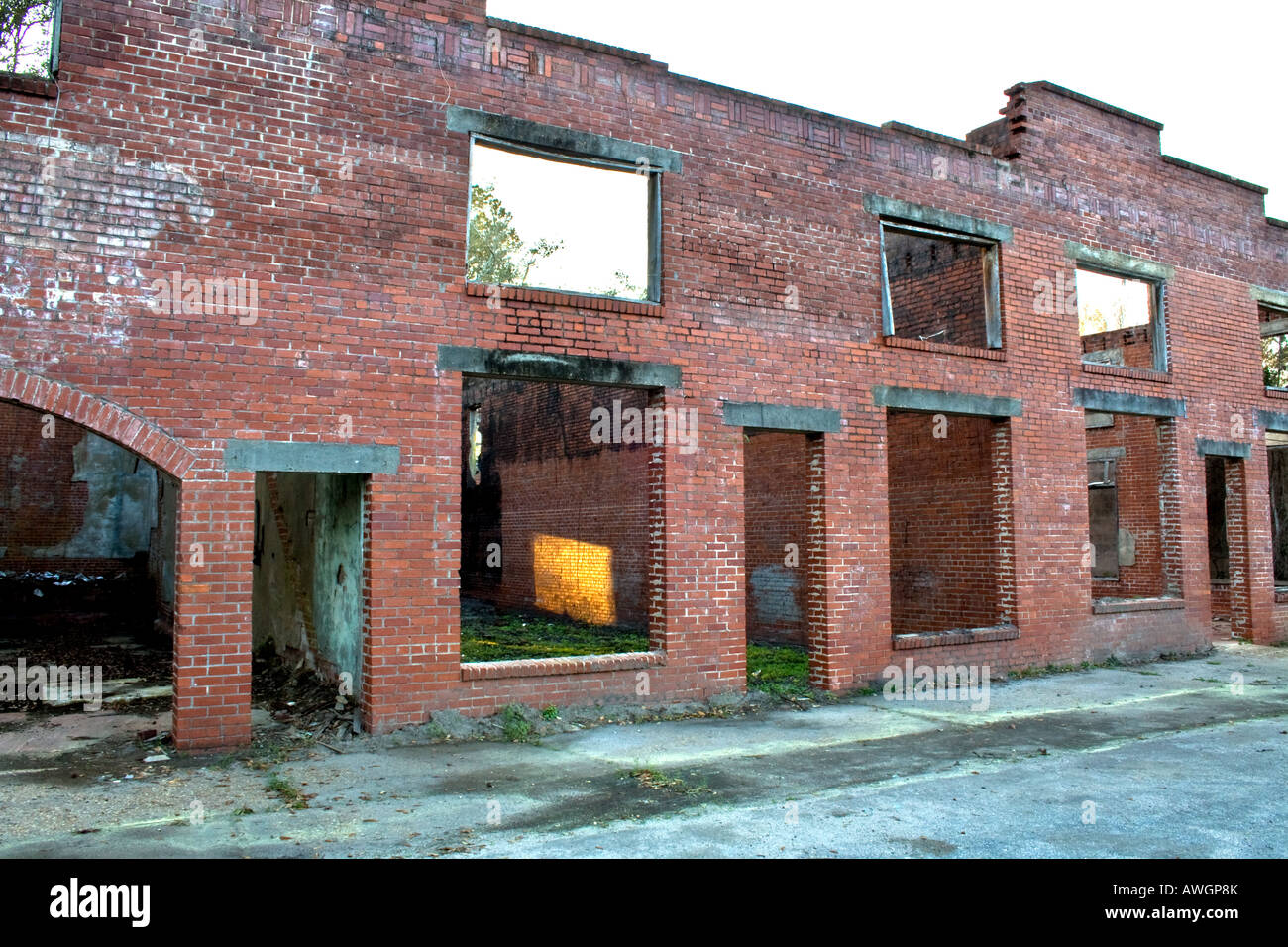 Old uninhabited brick store without windows, doors or roof with a ray of sunshine showing in side Stock Photo