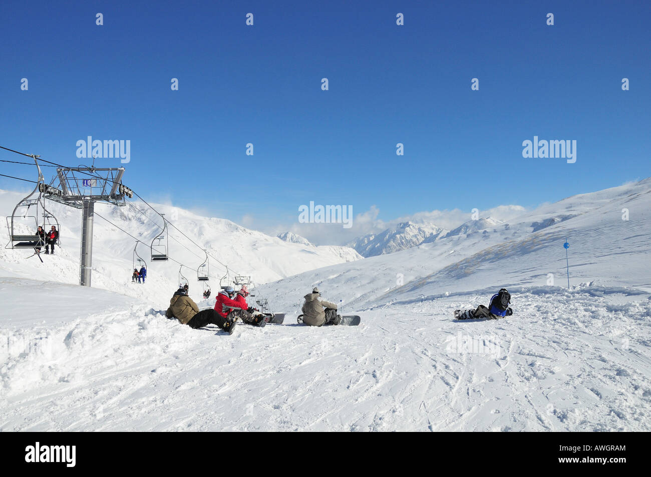 Snowboarders resting on a ski slope in the Pyrenees, Pas de la Casa