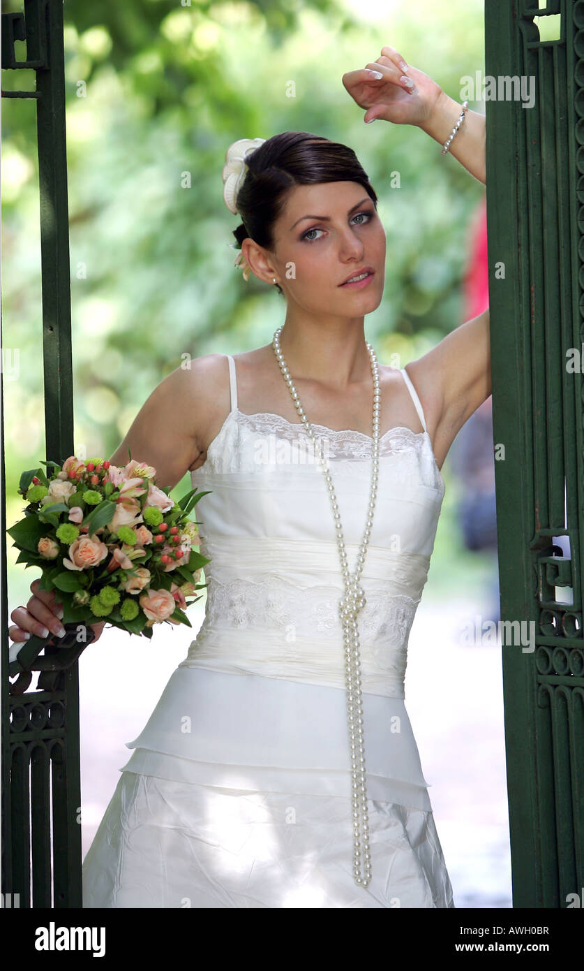 Beautiful young smiling bride on wedding day wearing traditional white dress. Stock Photo