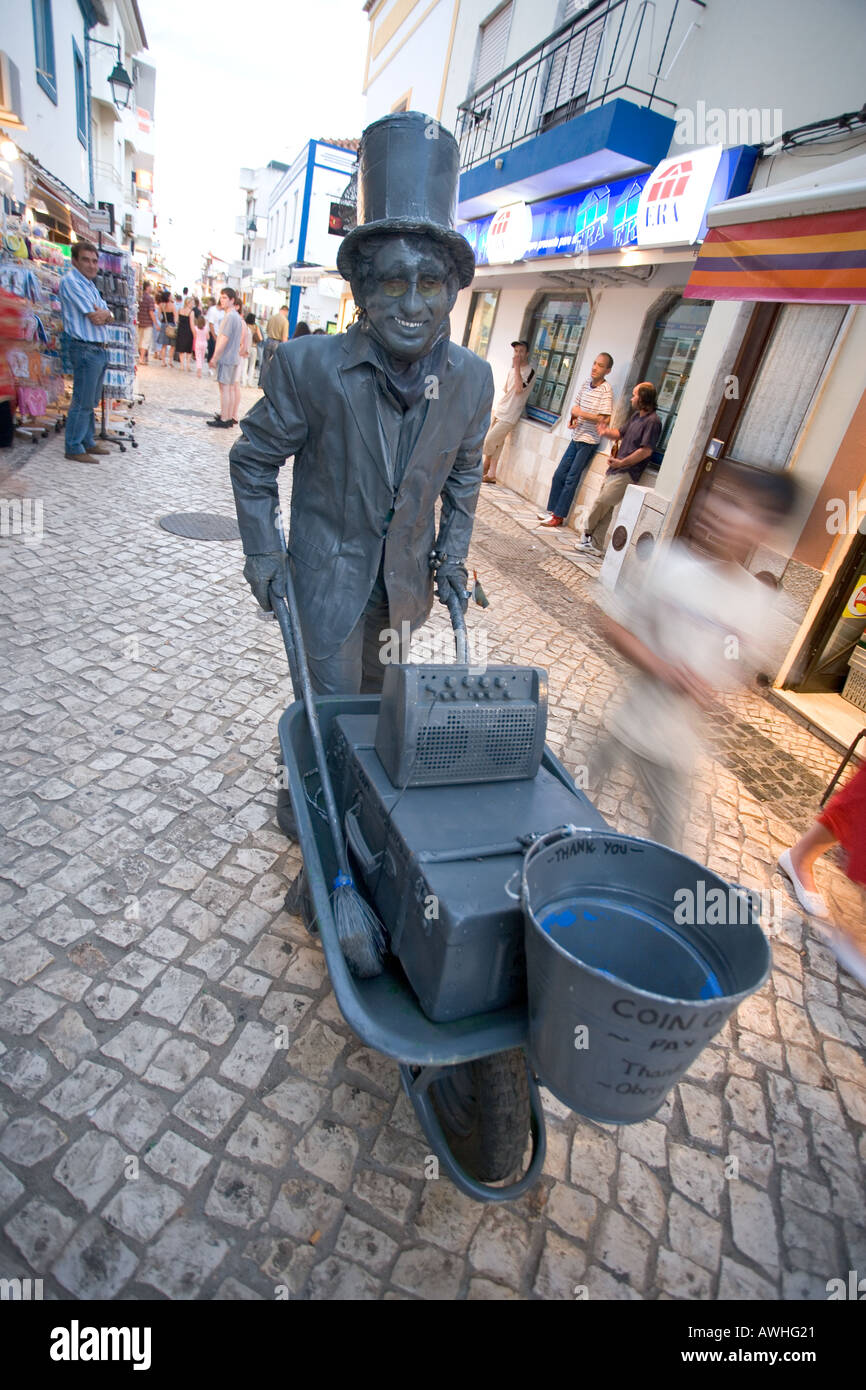 A street performer in costume walks the streets of Alvor Portugal attempting to earn some money Stock Photo
