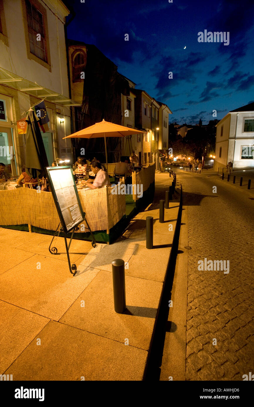 Residents and tourists have a late dinner at a restaurant with outdoor tables in the center of the fortified city of Bragança. Stock Photo