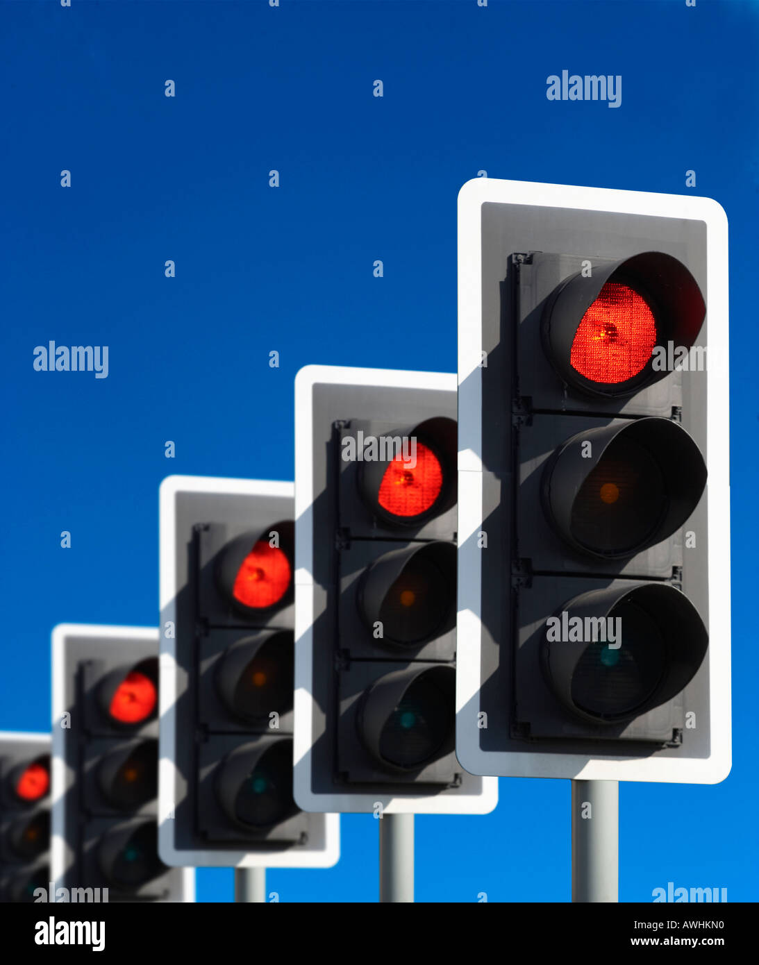 ROW OF FIVE ROAD TRAFFIC LIGHTS SHOWING RED WITH BLUE SKY Stock Photo