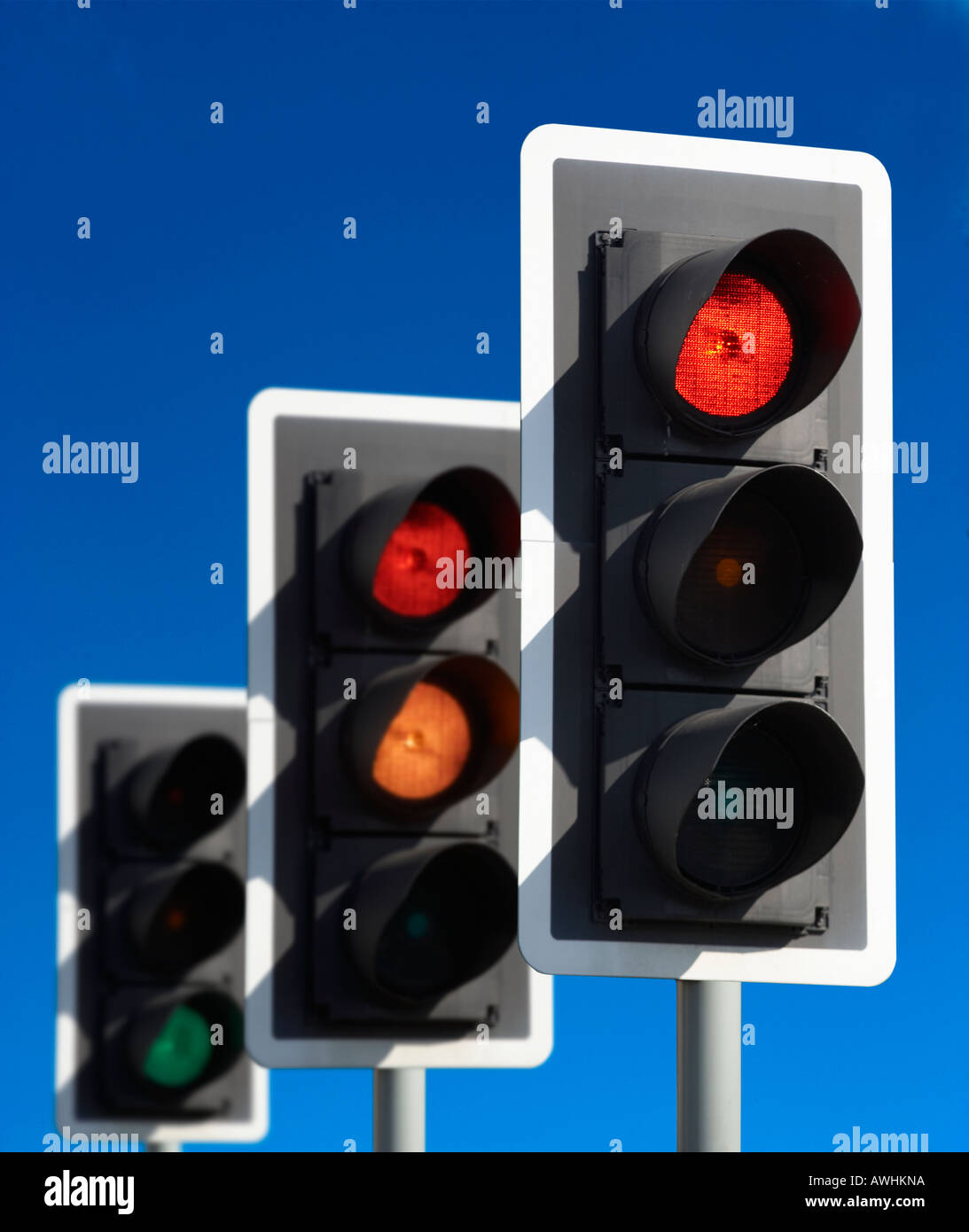 ROW OF THREE ROAD TRAFFIC LIGHTS SHOWING RED AMBER GREEN SEQUENCE WITH