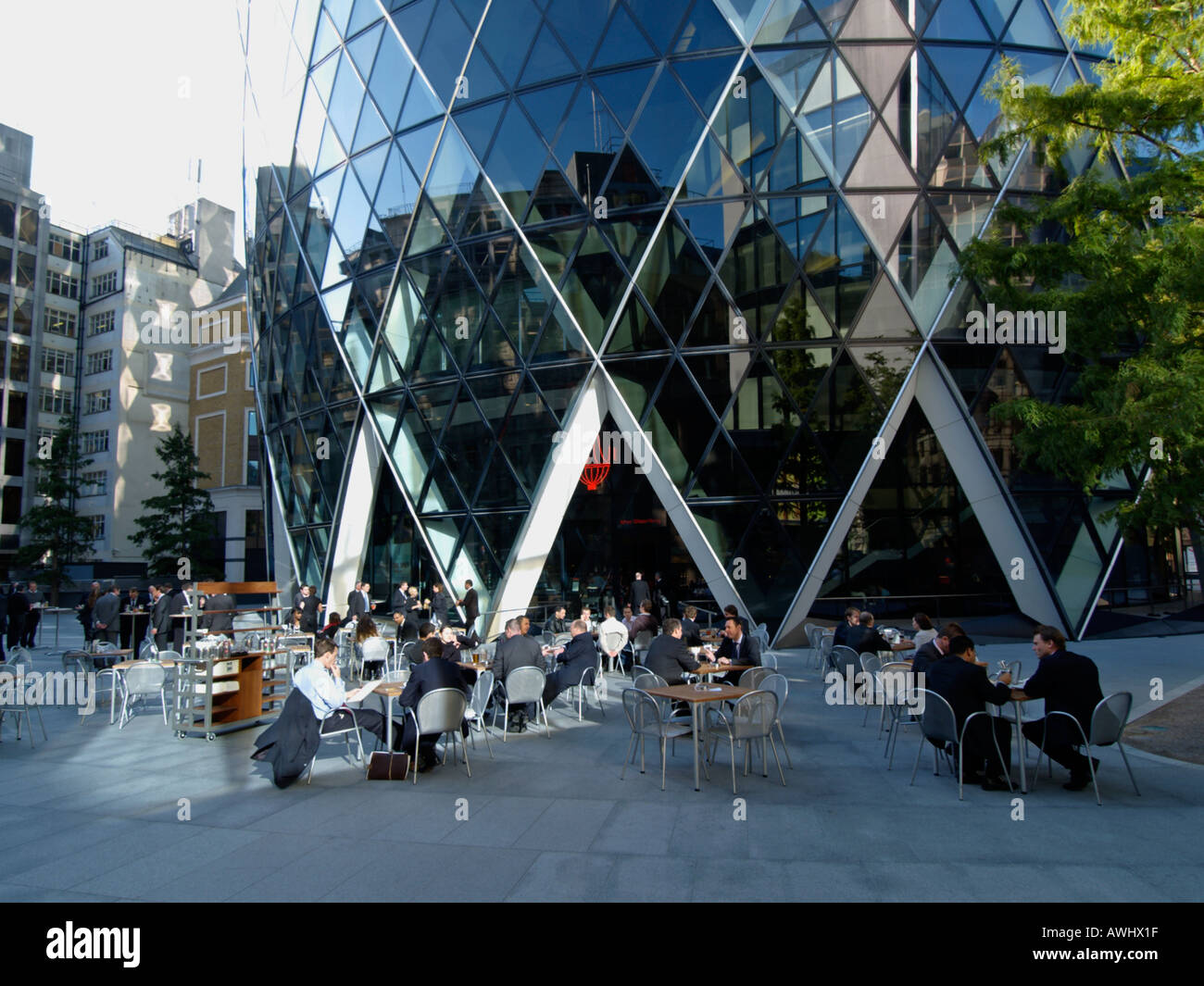 businessmen office workers having lunch lunchtime at the base of the Swiss Reinsurance building a k a the gherkin London UK Stock Photo